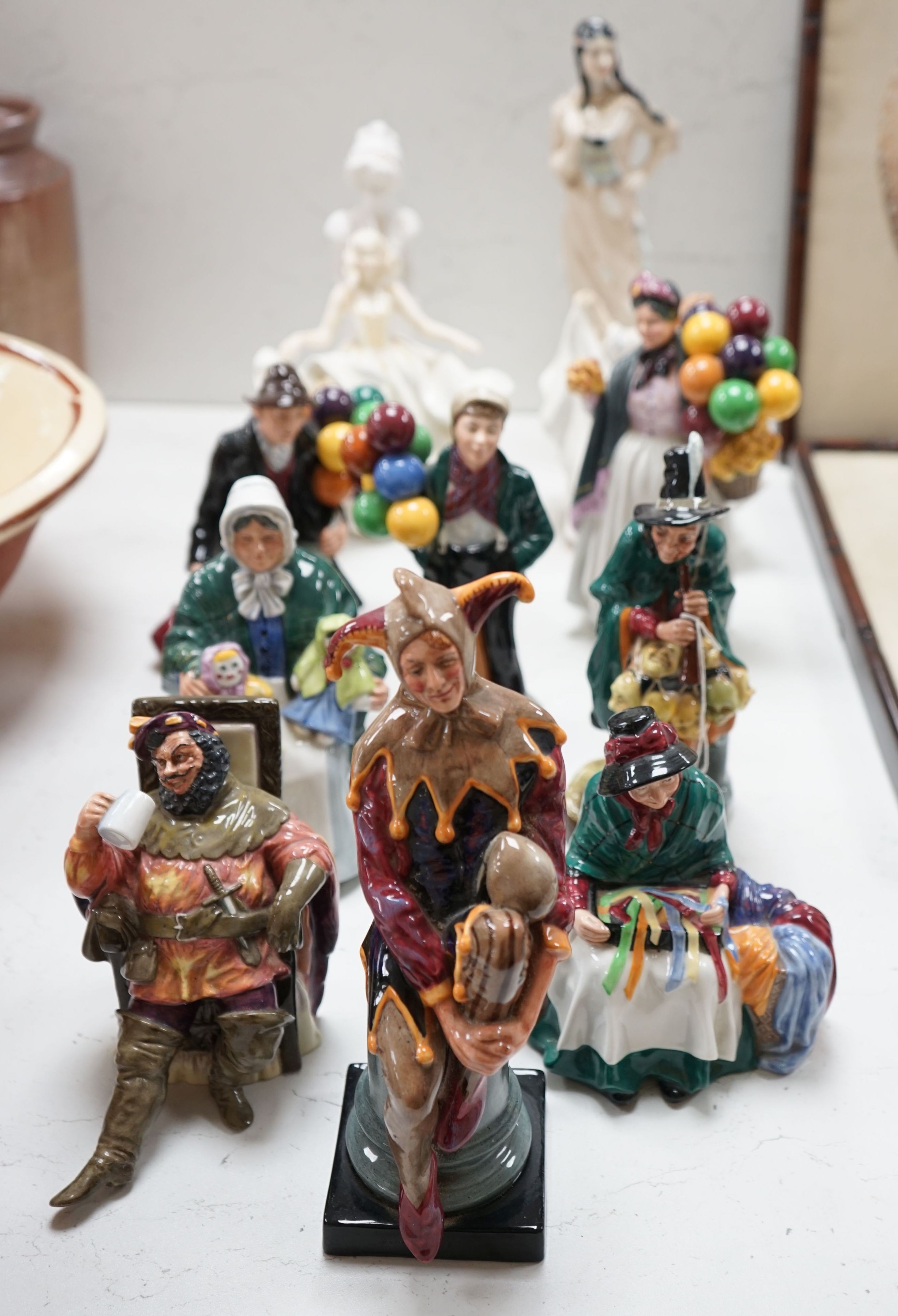 Eleven Royal Doulton figures - The Jester H.N. 2016, The Foaming Quart H.N. 2162, Silks and Ribbons HN 2017, The Rag Doll Seller HN 2944, The Mask Seller H.N. 2103, Balloon Boy HN 2934, The Balloon Man HN 1954, Biddy Pen